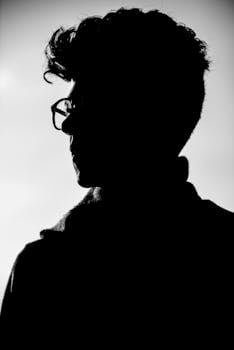 Artistic black and white profile silhouette of a man wearing eyeglasses.